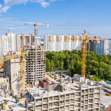 Urban construction site with cranes and buildings under development.