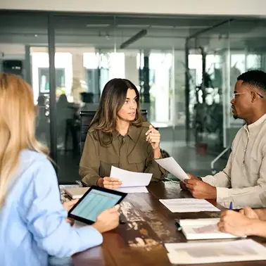 Colleagues having a meeting around a meeting room table.