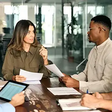 Colleagues having a meeting around a meeting room table.